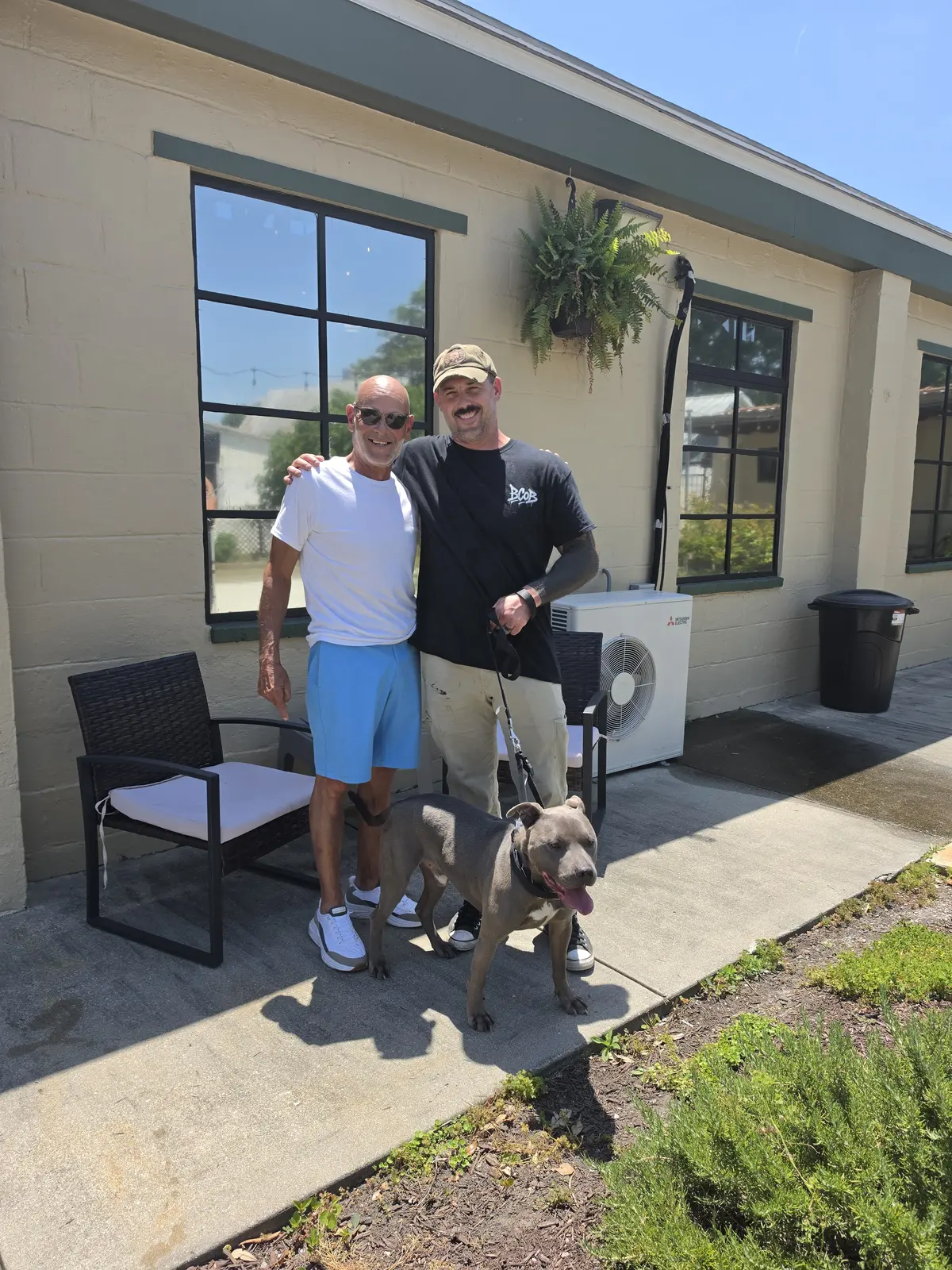 Members of the Because of Bubbles team standing with a rescue dog